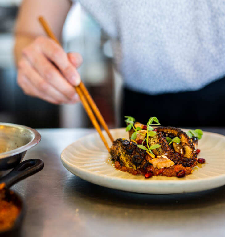 Enjoying cooked octopus with chopsticks.